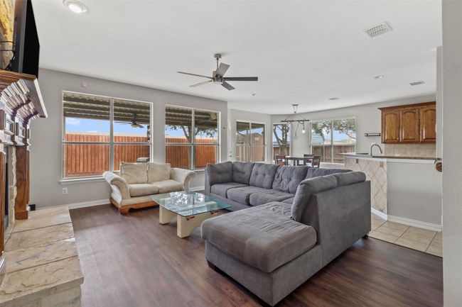 Living room with a ceiling fan and dark wood-style flooring | Image 14