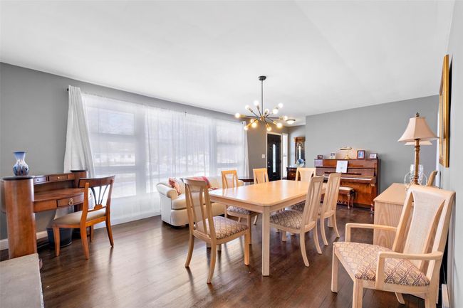 Dining area featuring a chandelier and dark wood-style flooring | Image 8
