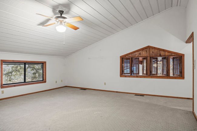 Carpeted spare room featuring lofted ceiling, ceiling fan, and wooden ceiling | Image 23