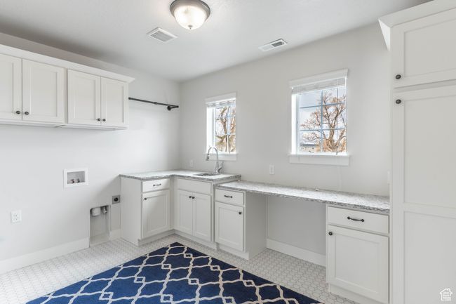 Laundry room with quartz countertops. | Image 25
