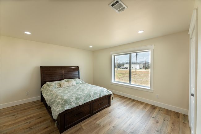 Bedroom featuring baseboards, recessed lighting, visible vents, and light wood-style floors | Image 9