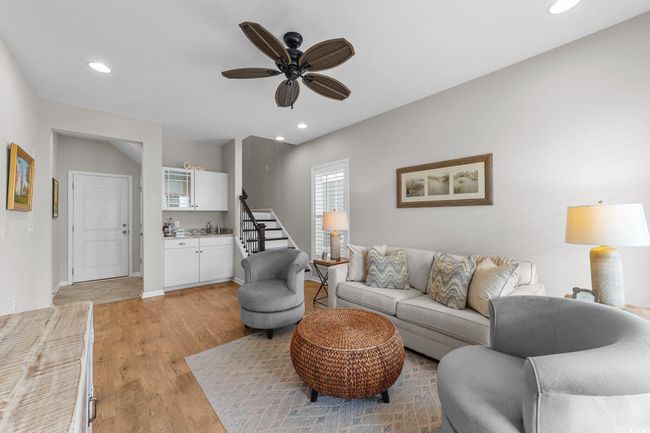 Living area with light wood finished floors, ceiling fan, recessed lighting, stairway, and baseboards | Image 20