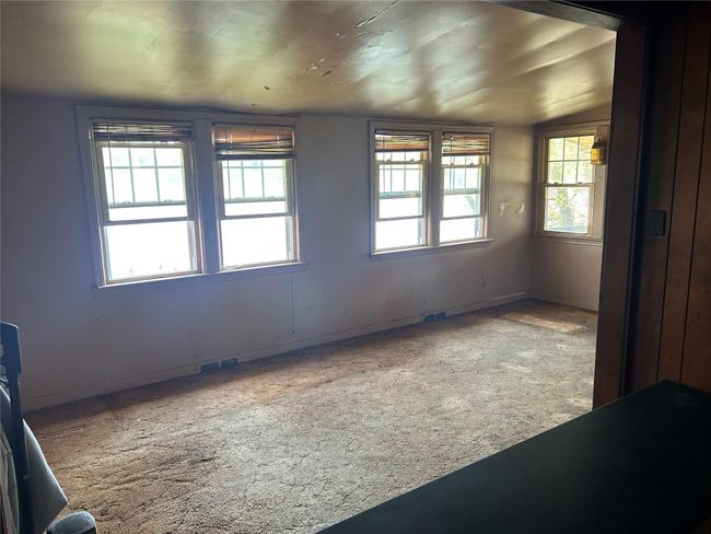 Empty room with a wealth of natural light, visible vents, and carpet | Image 13