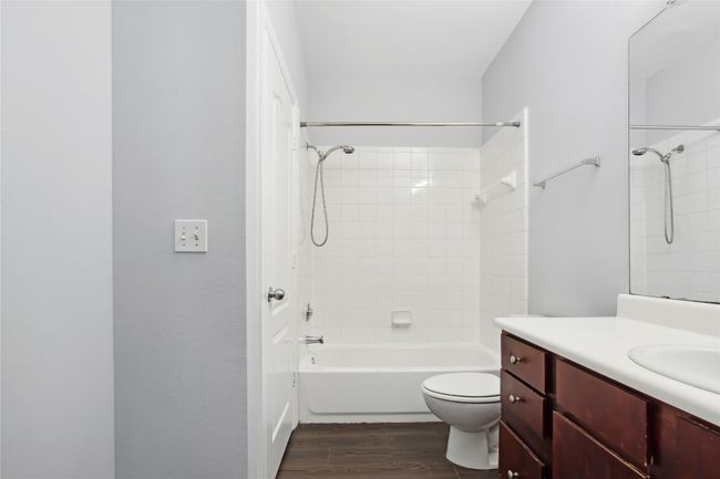 Bathroom with vanity, toilet, wood finished floors, and shower / bath combination | Image 15