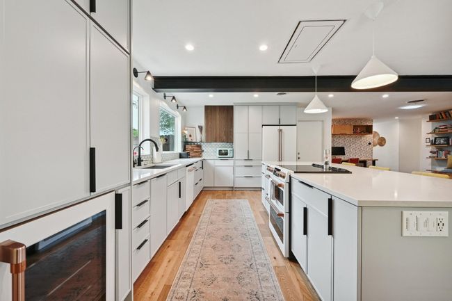 Featuring upgrades GE Cafe series appliances including a built-in electric range, dishwasher, and fridge, plus a wine fridge. | Image 11