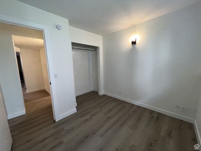 Unfurnished bedroom featuring wood finished floors, baseboards, and a closet | Image 11