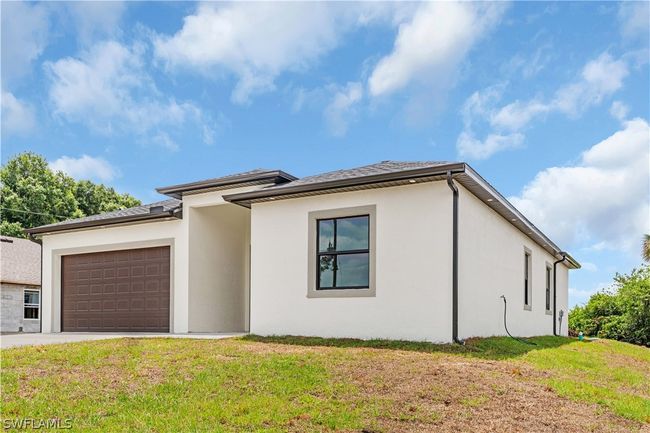 View of front of property featuring a garage and a front yard | Image 13