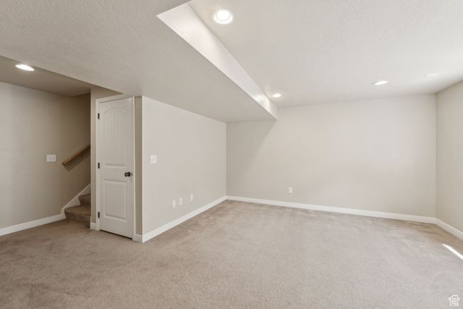 Finished basement with light colored carpet, recessed lighting, stairway, and a textured ceiling | Image 38