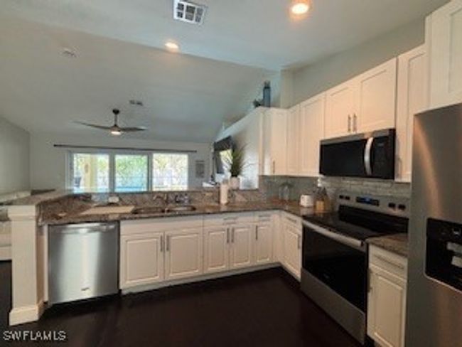 Kitchen featuring white cabinets, stainless steel appliances, and ceiling fan | Image 4