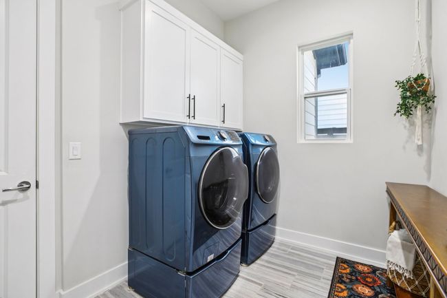 Laundry room featuring cabinet space, washer and dryer, and light wood-style floors | Image 31