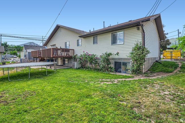 Back of house with a trampoline and a deck | Image 30