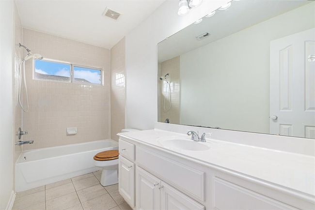 This full-sized secondary bathroom features plenty of storage space, and a bath/shower combination with a transom window allowing in more natural light! This bathroom is tucked between the two secondary bedrooms on this side of the home! | Image 36