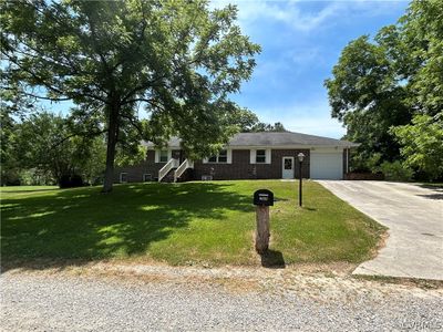 View of front facade featuring a front lawn and a garage | Image 1