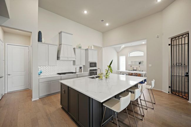 The focal point is a sleek island thatnot only provides additional counterspace but also serves as a casualgathering spot. There's also tons of extra cabinetry space under the island. | Image 7