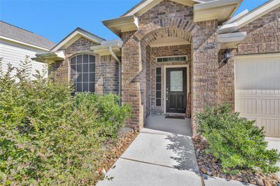 Here is a close up of the front entry featuring covered front porch with high ceiling, curved architecture brick detailing and paneled windows adding elegance and design. | Image 2