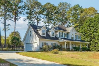 View of front of home featuring a porch, a front lawn, and a garage | Image 1