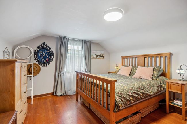 Bedroom featuring wood finished floors, baseboards, and lofted ceiling | Image 12