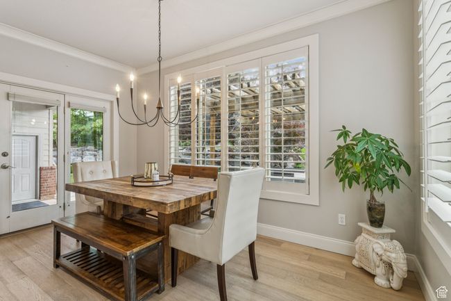 Dining area with light wood-style flooring, crown molding, and a chandelier | Image 19