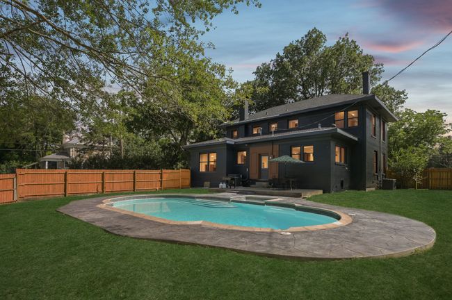 Back of house with a patio, central AC unit, a pool with connected hot tub, and a chimney | Image 40