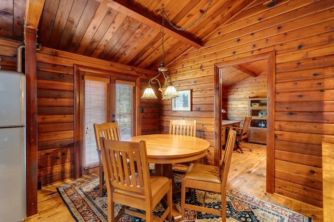 Dining area featuring wooden ceiling, light wood-type flooring, and wooden walls | Image 14