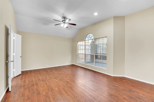 Empty room featuring wood-type flooring, ceiling fan, and vaulted ceiling | Image 28