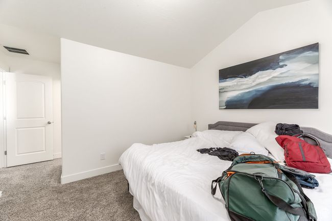 Bedroom featuring carpet, visible vents, baseboards, and lofted ceiling | Image 13