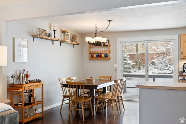 Dining space featuring wood finished floors, a chandelier, and baseboards | Image 14