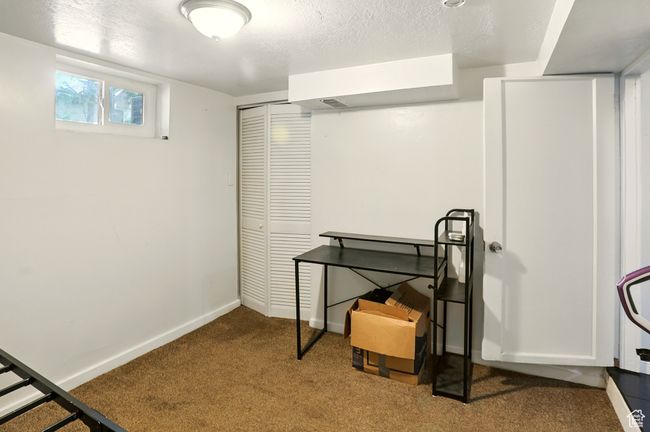 Basement featuring carpet floors and a textured ceiling | Image 21