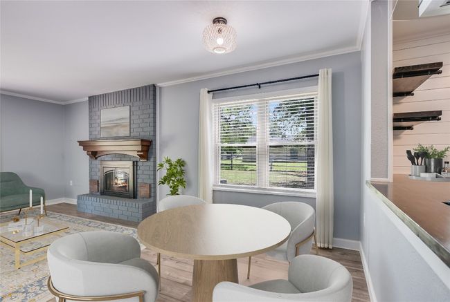 Dining space with wood finished floors, ornamental molding, and a brick fireplace | Image 15