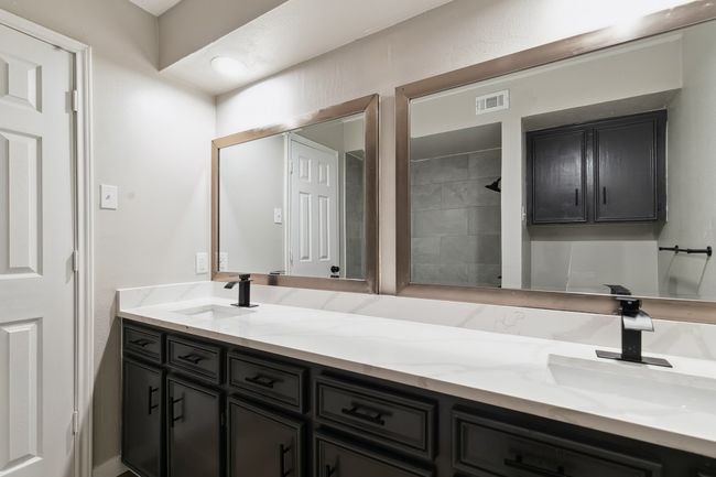 Bathroom with double vanity, visible vents, a tile shower, and a sink | Image 27
