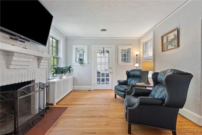 Sitting room featuring light hardwood / wood-style flooring, ornamental molding, and a brick fireplace | Image 3