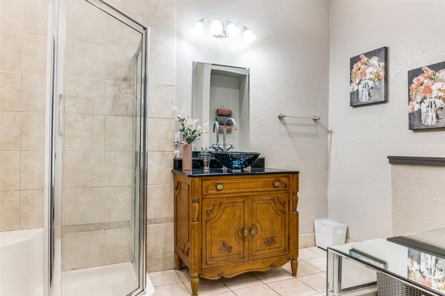 Bathroom with a shower stall, vanity, and tile patterned flooring | Image 9