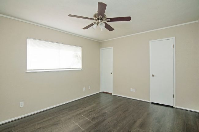Spare room with crown molding, dark wood-type flooring, and ceiling fan | Image 13