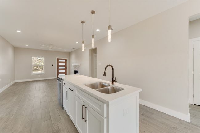 Kitchen featuring a fireplace, open floor plan, ceiling fan, recessed lighting, and light wood-type flooring | Image 15