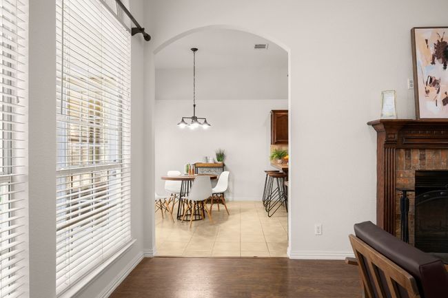 Dining room with light tile patterned flooring, a fireplace, arched walkways, and a chandelier | Image 12
