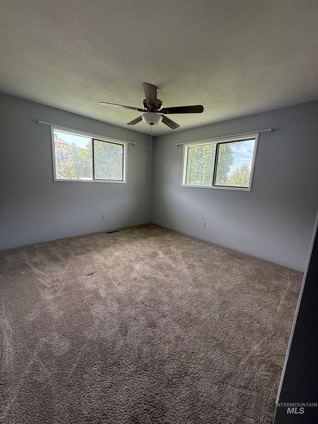 Carpeted spare room with a textured ceiling and ceiling fan | Image 28