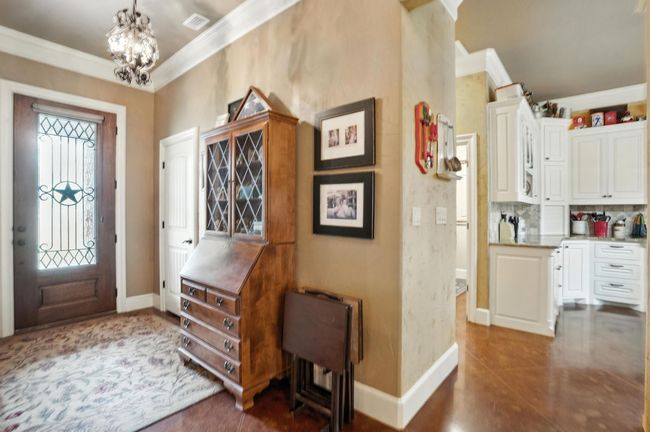 Entrance foyer with crown molding and a chandelier | Image 6