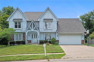 View of front of property with a front yard and a garage | Image 1