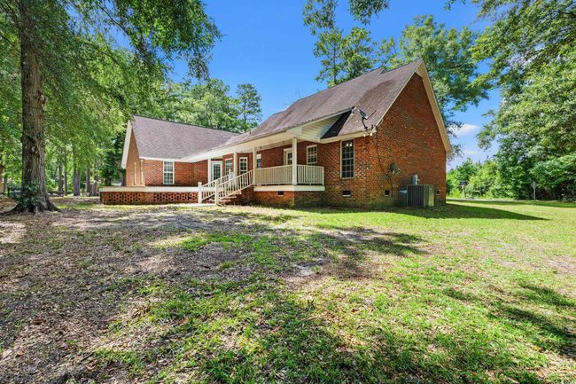 View of front of house featuring crawl space, a porch, a front lawn, and brick siding | Image 33