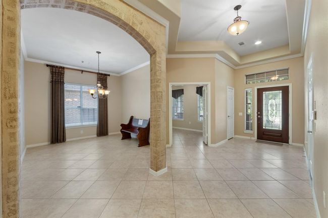 As soon as you step through the beautifully adorned glass front door, you're welcomed by a spacious entryway featuring elegant crown molding throughout, making it refined and inviting interior. | Image 7
