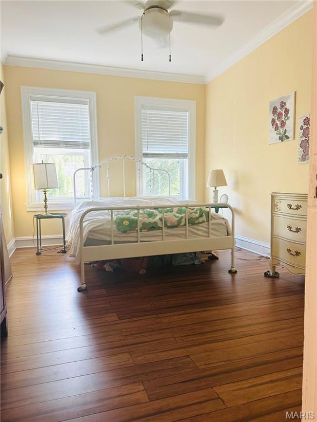 Bedroom with crown molding, wood-type flooring, and ceiling fan | Image 9