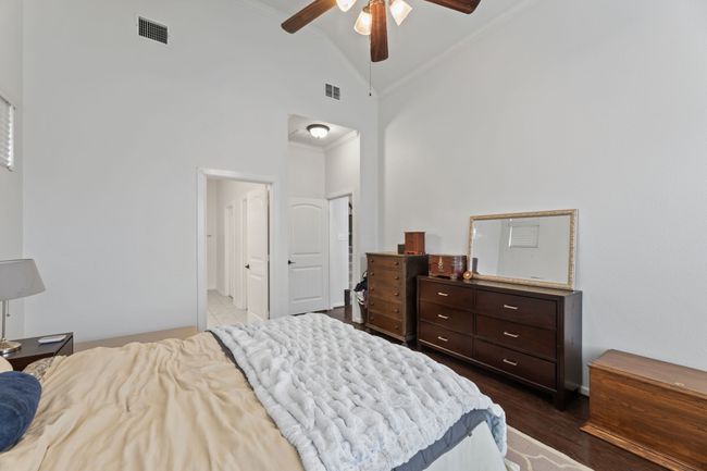 Bedroom featuring ornamental molding, dark wood-style floors, high vaulted ceiling, and a ceiling fan | Image 22