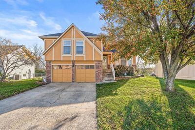 View of front of home featuring a front yard, central AC, and a garage | Image 2