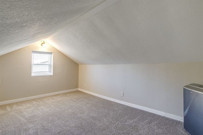 Additional living space featuring a textured ceiling, lofted ceiling, and carpet flooring | Image 15