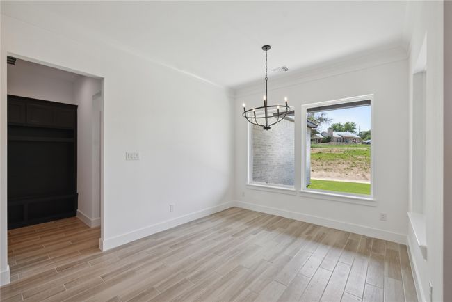 Unfurnished dining area featuring a notable chandelier and light hardwood / wood-style flooring | Image 20