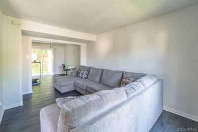 Living room featuring an inviting chandelier and dark hardwood / wood-style flooring | Image 2