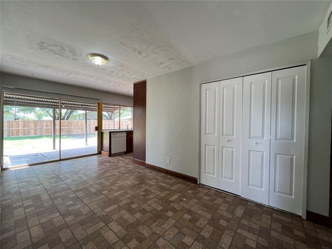 Unfurnished living room with baseboards and brick patterned floors | Image 4
