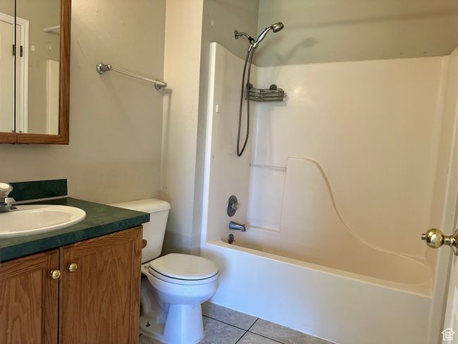 Full bathroom featuring tile patterned flooring, vanity, and washtub / shower combination | Image 10