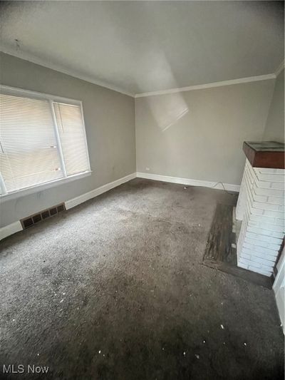 living room with ornamental molding and a fireplace | Image 2