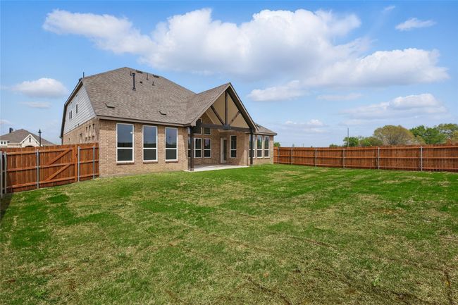 Back of house featuring a fenced backyard, brick siding, a yard, and a patio area | Image 27